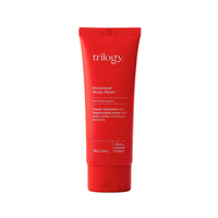 Red tube of Trilogy Botanical Body Wash on a light gray background