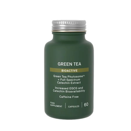 Green tea supplement bottle with white cap on a black background
