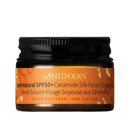 Antipodes sunscreen jar with black lid on a beige background