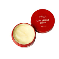 Red container of Trilogy Everything Balm on a white background